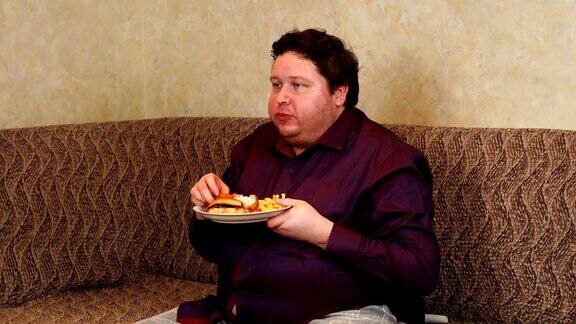 胖子在家里一边看电视一边吃快餐