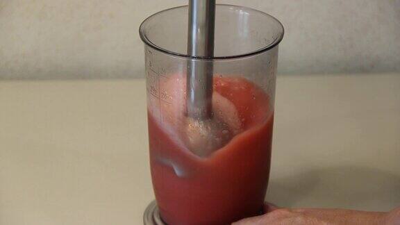 手搅拌机用搅拌机搅拌新鲜的西瓜汁