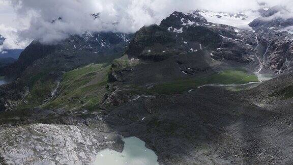 夏季意大利Valmalenco的费拉里亚冰川泻湖山脉被云层笼罩空中前倾显示