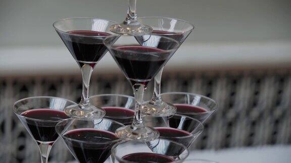 自助餐桌上摆着装有红酒的金字塔形鸡尾酒杯
