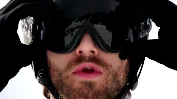 男子脸部细节调整头盔准备滑雪登山滑雪活动冬季滑雪者在高山户外运动前视图慢动作60p全高清视频