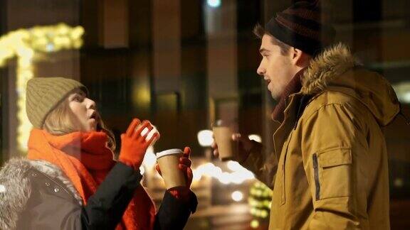 快乐的女士穿着暖和的衣服和她的男朋友聊天喝着咖啡