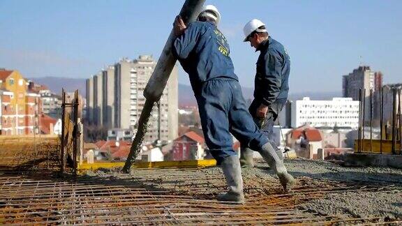 工人们在建筑物顶部浇筑混凝土