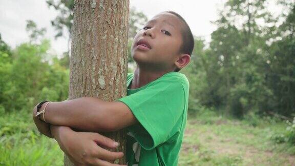 森林里的孩子拥抱着树地球日