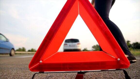 一个年轻女子在交通中设置了三角形警示牌