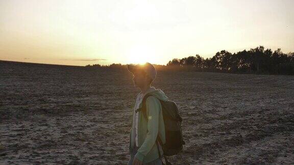 背着背包的小男孩在日落时分在户外散步