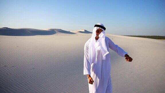 在晴朗的夜晚活跃的年轻男子阿联酋酋长在沙漠中漫步享受生活