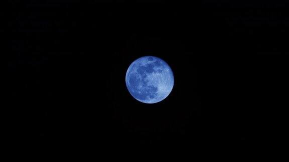 蓝色的满月在夜空中移动了4K