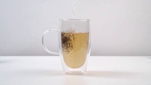 在一个大玻璃杯中加入两杯热水冲泡茶包