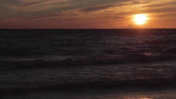 日落时波浪起伏的沙滩