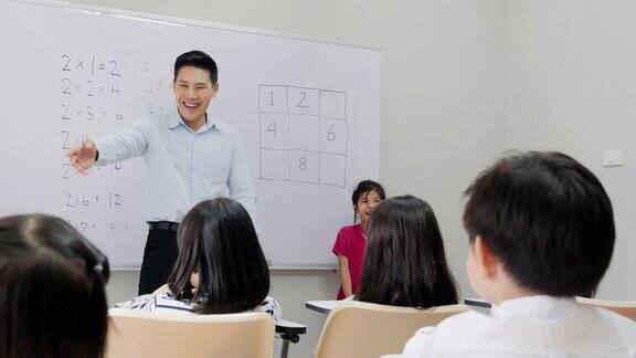老师在学校向学生提问小女孩协助老师上课教育