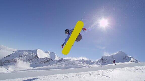 慢动作:年轻的职业滑雪板运动员在阳光灿烂的雪公园半管跳跃