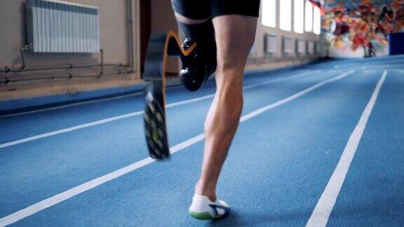 一个男人用假腿在跑道上慢跑特写