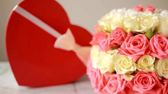 一束粉红色和白色的玫瑰盒子里有一个心形的礼物