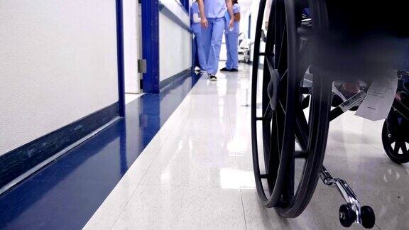 在医院的走廊里病人被用轮椅推着