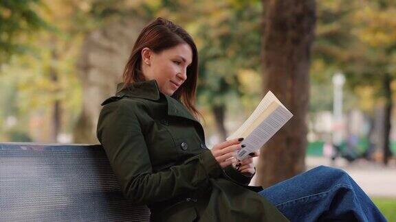 一个女人坐在公园的长椅上看书