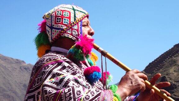 老人穿着秘鲁传统服装吹着笛子