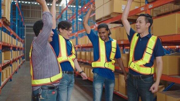 一群亚洲工人手牵手快乐庆祝仓库的成功物流库存团队合作的理念