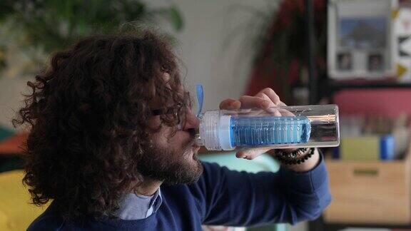 年轻人从可重复使用的瓶子里喝水