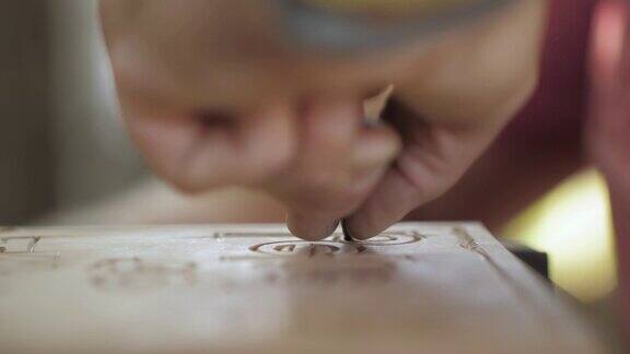 特写镜头木匠用凿子用木雕雕刻字母木工和工艺概念