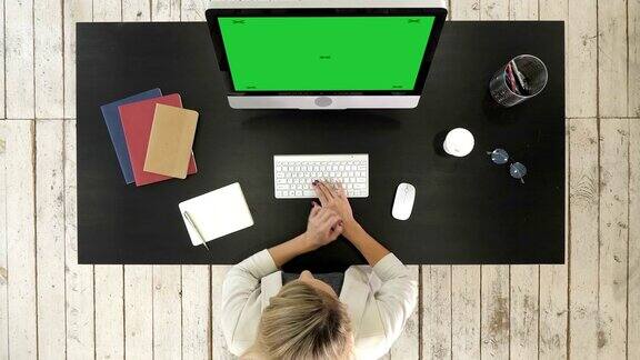 在办公室用电脑工作的女商人绿屏模拟显示