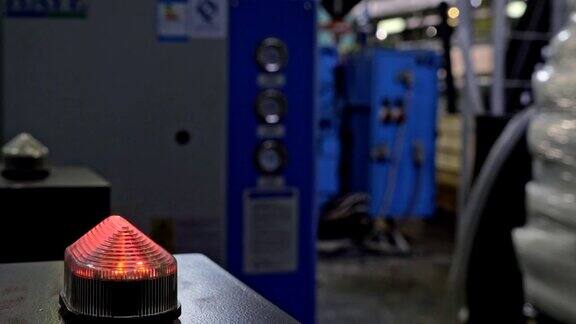 加工机上的警告灯卫生纸生产车间大车间机器上红光闪烁金属柜上的红色警报器工作区域的安全警告灯