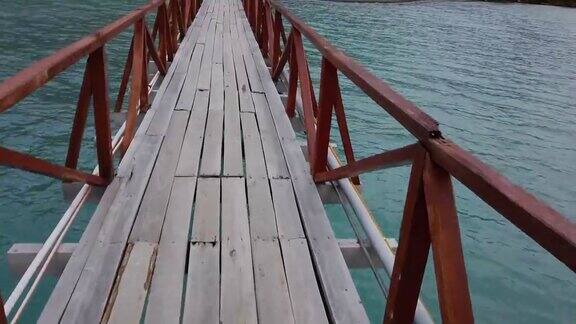 一个男人走过一座桥一座横跨湖上的桥一座横跨巴塔哥尼亚湖上的桥