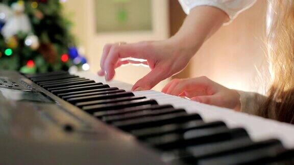 妈妈帮助孩子弹钢琴近距离的手指敲击钢琴键