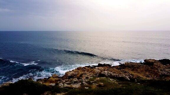 航道海浪冲击着纯净的岩石海岸无人机视角清澈的蓝色清澈的水