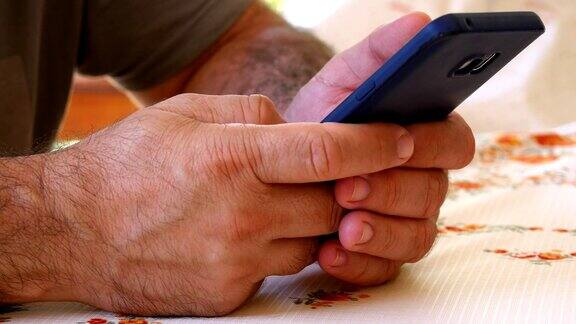 一个用智能手机上网或浏览社交媒体的男人的手的特写手机上瘾