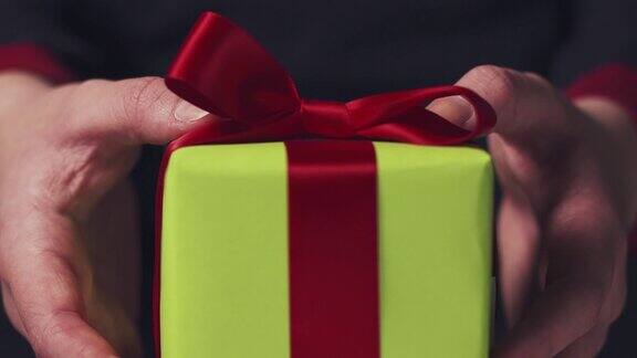 少女展示绿色礼盒上面有红色丝带和蝴蝶结
