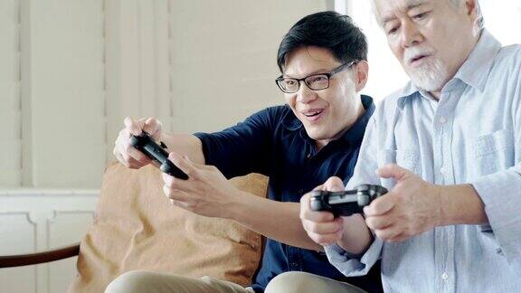 老父亲和他已成年的儿子喜欢在客厅里一起玩电子游戏