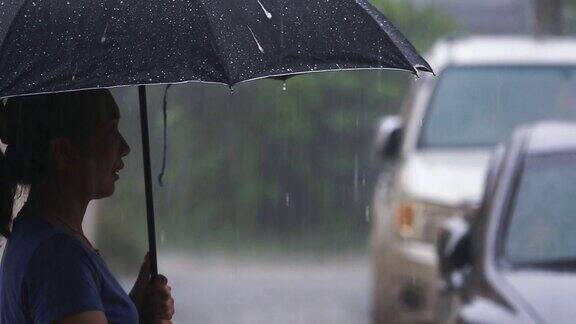 SLOMO女人站在城市街道在雨天