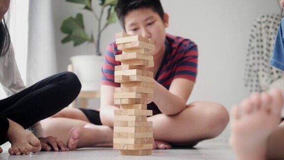 亚洲儿童在家中地板上一起玩拆积木游戏生活理念
