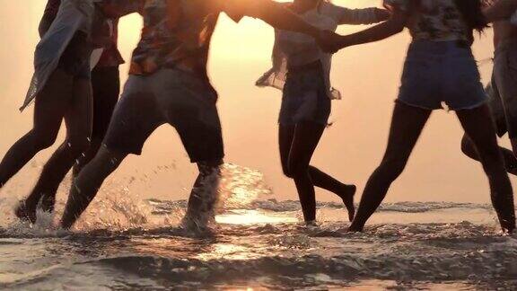 一群朋友在海滩上玩耍的剪影缓慢的运动假期