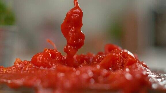 慢镜头:碎番茄落入美味的自制番茄酱中