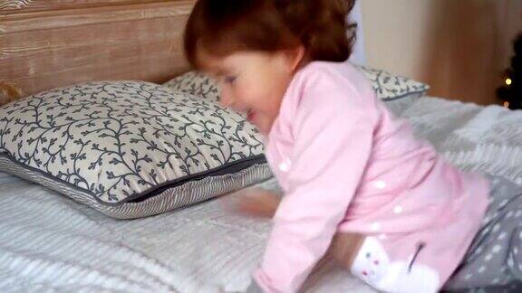 一个快乐的小女孩穿着睡衣躺在床上