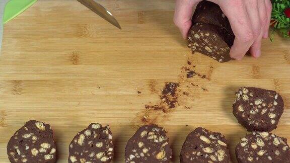 用菜刀在砧板上切巧克力香肠新鲜的巧克力甜点在家烘烤烹饪