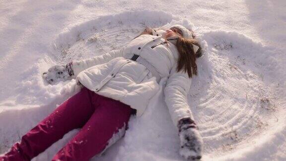 少女享受在新雪中做一个雪天使