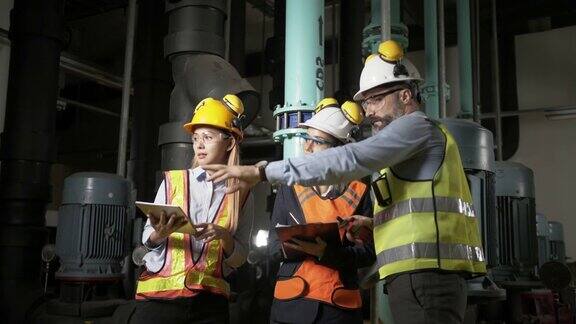 团队工程师在工厂的泵系统油管工作