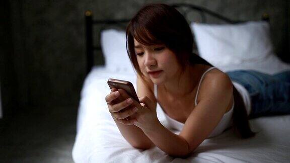 年轻女子在床上玩手机