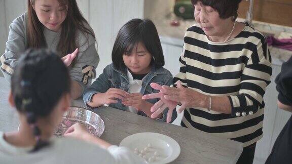 中国的老年人家庭为春节团圆饭准备中国食物“汤圆”糯米团