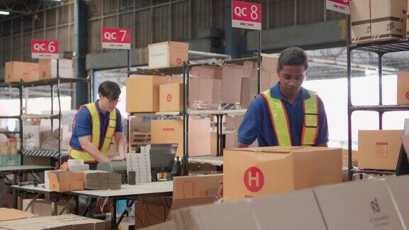 两名亚洲仓库工人在仓库检查包装产品物流而工作人员则用激光条码扫描仪将纸板箱、配送中心、仓库等放置于运输中