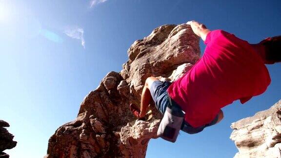 极端自由攀爬的人挂在岩石上的低角度