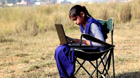 少女在户外使用笔记本电脑
