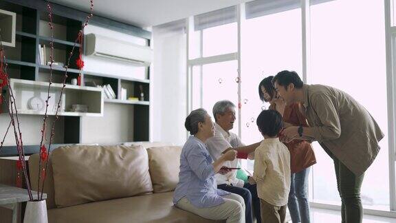 春节期间亚洲华人的祖父母在家给孙子发红包