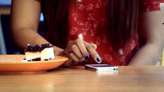 亚洲女孩在餐厅用智能手机