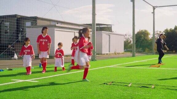 女子足球队或足球队队员在足球或足球场上进行敏捷性和快速跑训练
