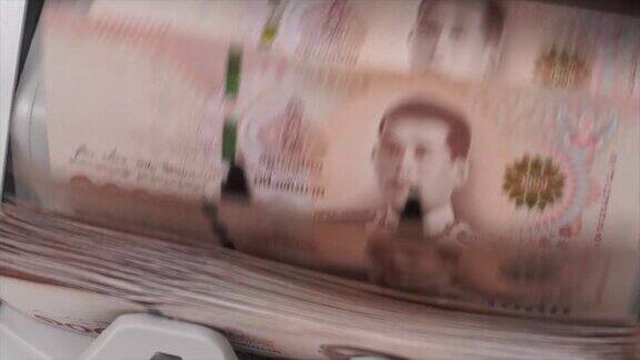慢动作特写镜头的泰国钞票一千泰铢(100泰铢)计数在钞票柜台机器货币计数银行柜台机械纸币金融市场