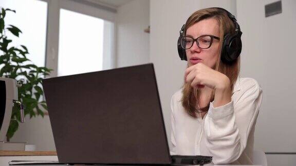 戴着耳机用笔记本电脑进行视频通话的女人